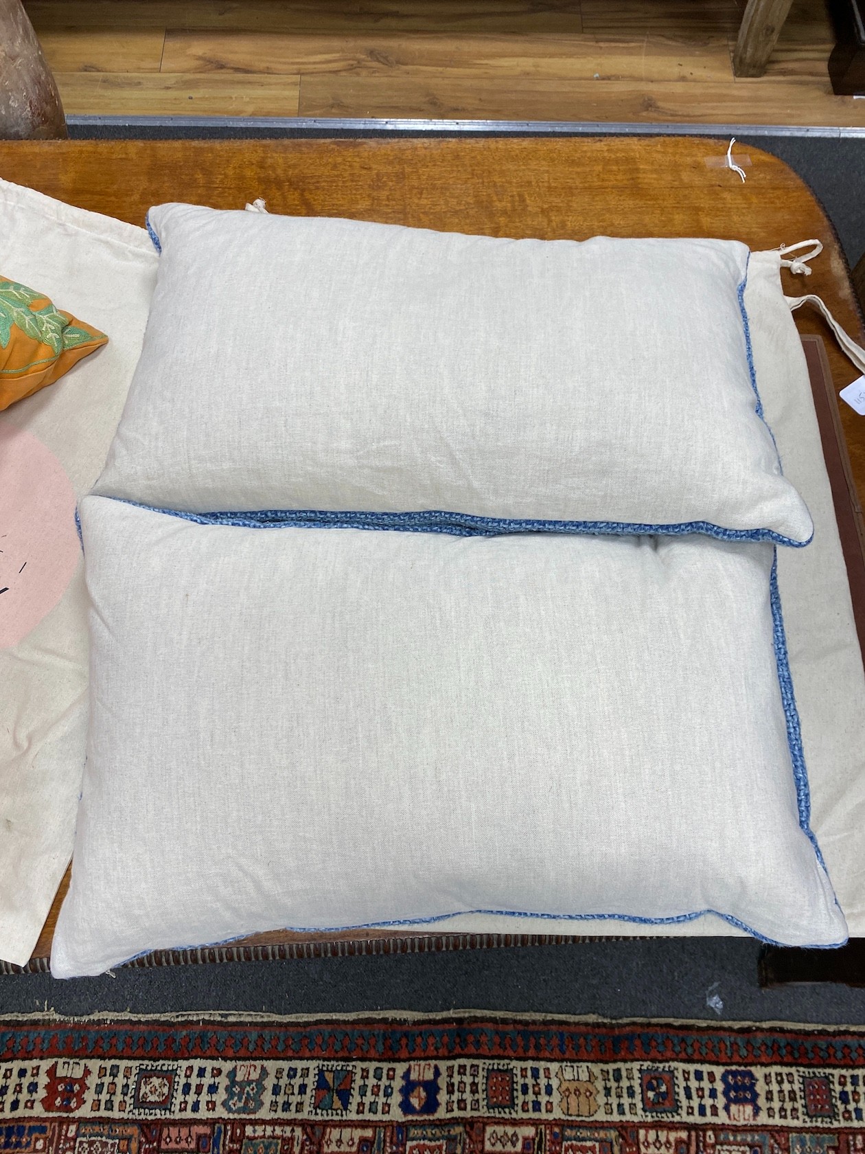 Two pairs of polychrome floral embroidered and blue woven cushions, larger 50cm square.
